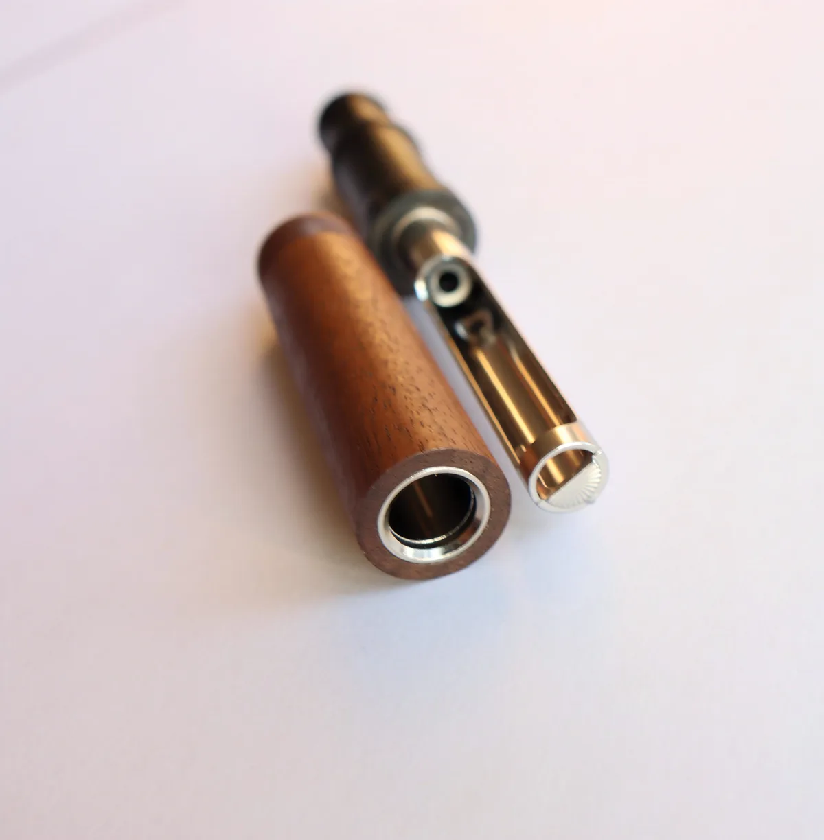 Close-up of AIRITU R-W000 wood outer sleeve beside its separated mouthpiece and reflective tube